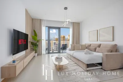 a living room with a couch and a tv at LUX The Vida Marina Residence in Dubai
