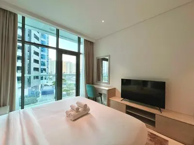 a bedroom with a bed with a flat screen tv at LUX Infinity Pool, Private Beach, GYM, Parking in Dubai