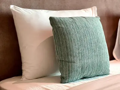 a green pillow sitting on top of a bed at LUX Infinity Pool, Private Beach, GYM, Parking in Dubai