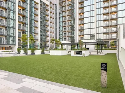 an open courtyard in a building with a green lawn at FIRST CLASS 2BR Bright and Elegant Living in Dubai