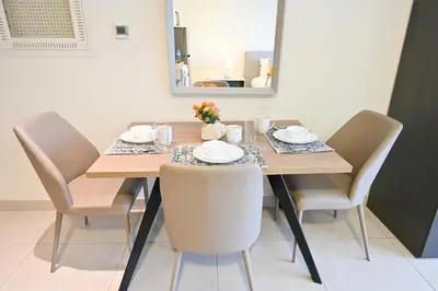 a dining room table with chairs and a mirror at Sylish Studio with Balcony Views Near Dubai Mall in Dubai