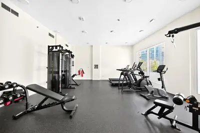 a gym with rows of treadmills and machines at Sylish Studio with Balcony Views Near Dubai Mall in Dubai