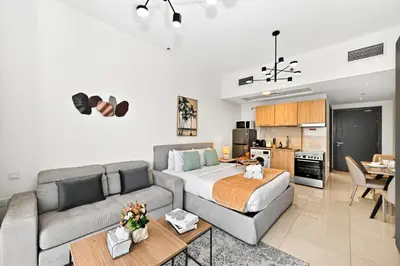 a living room with a bed and a couch at Sylish Studio with Balcony Views Near Dubai Mall in Dubai