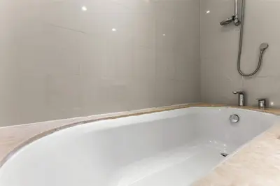 a white bath tub in a bathroom with a shower at FIRST CLASS 2BR Luxury Living in Downtown in Dubai