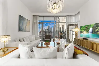 a living room with white furniture and a large window at FIRST CLASS 2BR Luxury Living in Downtown in Dubai