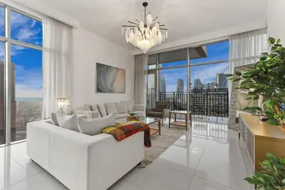 a living room with a white couch and large windows at FIRST CLASS 2BR Luxury Living in Downtown in Dubai