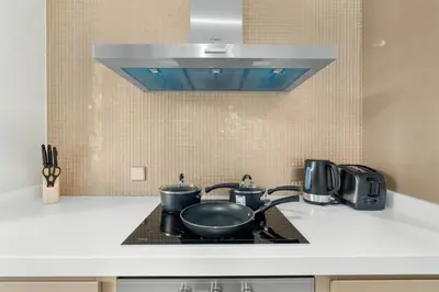 a kitchen with two pots and pans on a stove at Your Hollywood-Style Hideaway -DAMAC Paramount in Dubai