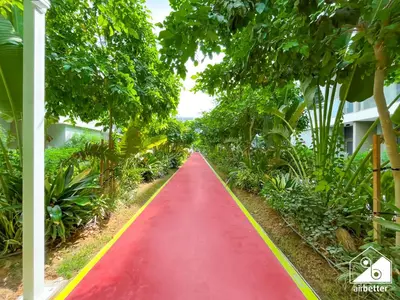a red path in the middle of a garden at Luxury 1BR Escape, Resort-Style Living in Dubai in Dubai