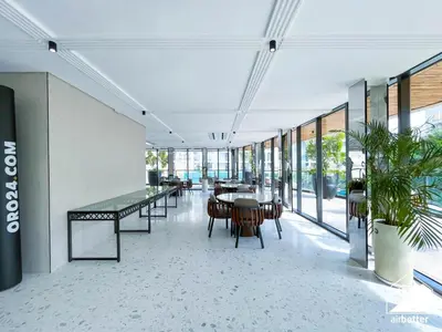 an empty room with tables and chairs and windows at Luxury 1BR Escape, Resort-Style Living in Dubai in Dubai