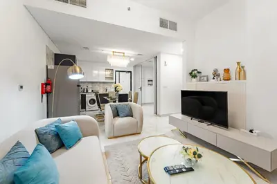 a living room with a couch and a tv at FIRST CLASS 2BR Chic Getaway Close to Metro in Dubai