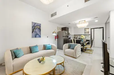 a living room with a couch and a table at FIRST CLASS 2BR Chic Getaway Close to Metro in Dubai