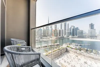 a balcony with two chairs and a view of the city at Burj Khalifa and Dubai Canal Views, Minutes from Downtown Dubai, Convenient Metro Access - 15 Northside Tower 2, Business Bay by Deluxe Holiday Homes in Dubai