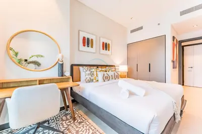 a bedroom with two beds and a desk and a mirror at Burj Khalifa and Dubai Canal Views, Minutes from Downtown Dubai, Convenient Metro Access - 15 Northside Tower 2, Business Bay by Deluxe Holiday Homes in Dubai