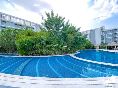 a swimming pool in front of a building at Spacious 1-BR with Balcony & Leisure Facilities in Dubai