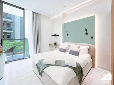 a bedroom with a large bed and a large window at Spacious 1-BR with Balcony & Leisure Facilities in Dubai