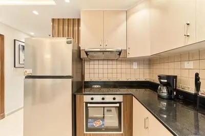 a kitchen with a stainless steel refrigerator and cabinets at FAM Living Elite Residence 1BR Walk to JBR Beach in Dubai