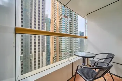 a table and chairs on a balcony with a view of skyscrapers at FAM Living Elite Residence 1BR Walk to JBR Beach in Dubai
