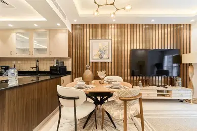 a dining room with a table and chairs in a kitchen at FAM Living Elite Residence 1BR Walk to JBR Beach in Dubai