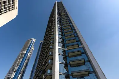 a tall building in front of two tall buildings at Spacious High-Floor 2BR with Stunning City and Burj Khalifa Views, Quick Drive to Downtown, and Steps from the Bus Station, Nobles, Business Bay by Deluxe Holiday Homes in Dubai