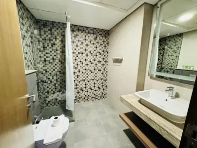 a bathroom with a sink and a toilet and a mirror at Stylish One Bed Apartment near Downtown in Dubai