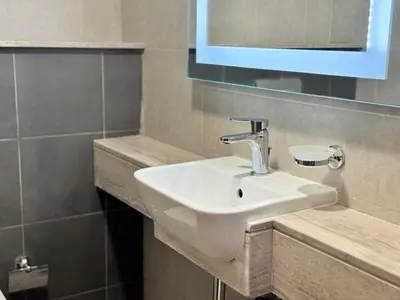 a bathroom with a white sink and a mirror at Stylish One Bed Apartment near Downtown in Dubai