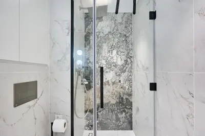 a shower with a glass door in a bathroom at Stylish 1BR Apartment, ZADA Tower with Pool & Gym, Business Bay in Dubai