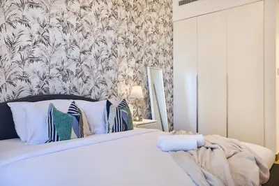 a bedroom with a bed with a floral wallpaper at Le Pont Apartment in Port de La Mer with Pool Access, Retreat near the Beach in Dubai