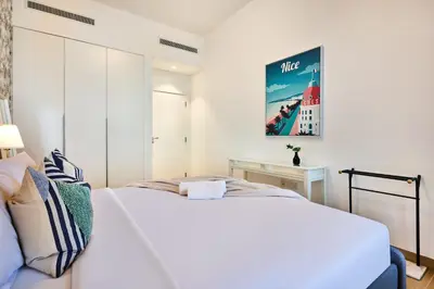 a bedroom with a large white bed and a desk at Le Pont Apartment in Port de La Mer with Pool Access, Retreat near the Beach in Dubai