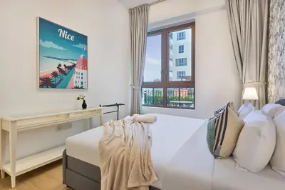 a bedroom with a white bed and a window at Le Pont Apartment in Port de La Mer with Pool Access, Retreat near the Beach in Dubai