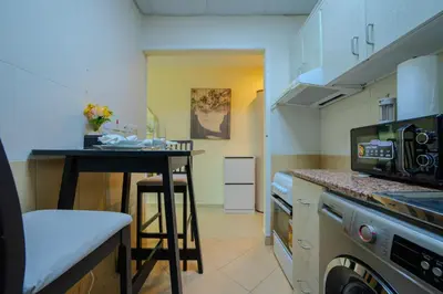 a small kitchen with a table and a microwave at Metrofront Stay - Walk to Iconic Dubai Spots in Dubai
