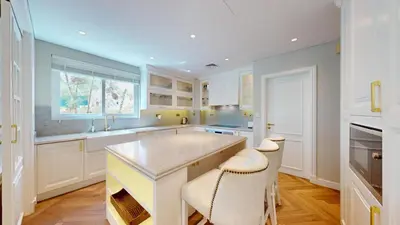 a kitchen with white cabinets and a large island at Vacationer l Family Villa with Private Pool, Private Garden in Dubai