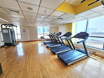 a gym with a row of treadmills in a room at SUNRISE HOMES - Stunning 1BR Marina View near Beach walk in Dubai