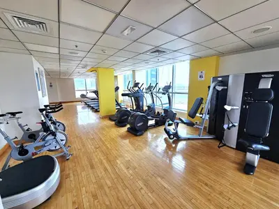 a gym with a bunch of treadmills and cardio machines at SUNRISE HOMES - Stunning 1BR Marina View near Beach walk in Dubai