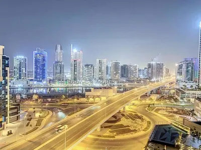 a city with a busy highway in front of tall buildings at Stylish Studio in Elite Downtown in Dubai