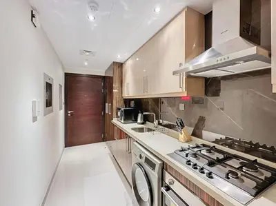 a kitchen with a sink and a stove top oven at Stylish Studio in Elite Downtown in Dubai