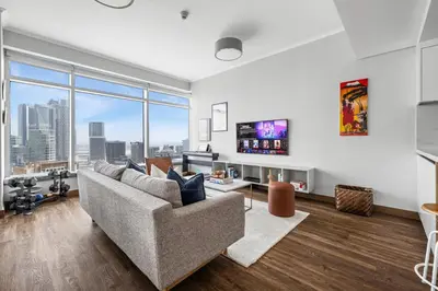 a living room with a couch and a large window at Luxury 1BR with Workspace Next To Dubai Mall in Dubai