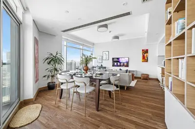 a dining room and living room with a table and chairs at Luxury 1BR with Workspace Next To Dubai Mall in Dubai