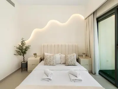 a white bedroom with a large bed and a window at Luxury 2BR- Pool with Burj View- 5 Min to Dubai Mall in Dubai