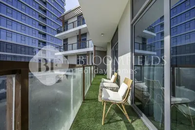 a balcony of a building with chairs and windows at Bloomfields Marquis 2020 in Arjan in Dubai