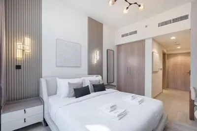 a bedroom with a large white bed with two towels on it at Downtown-Close Studio by Czech-In in Dubai