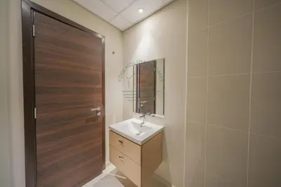 a bathroom with a sink and a wooden door at Spacious Private 4-Bedroom Villa for Families & Groups in Dubai