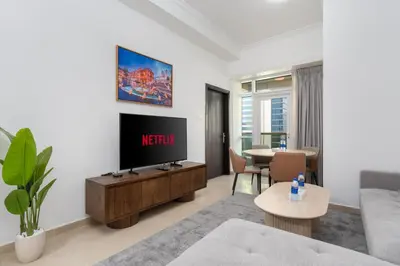 a living room with a television and a table at Samaya Holiday Homes - Lake City Stunning Suits Lake View - Next to Metro in Dubai