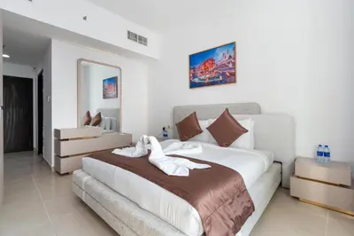 a bedroom with a large bed with white sheets at Samaya Holiday Homes - Lake City Stunning Suits Lake View - Next to Metro in Dubai