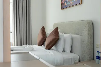a white couch with brown pillows in a living room at Samaya Holiday Homes - Lake City Stunning Suits Lake View - Next to Metro in Dubai
