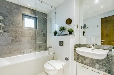a bathroom with a sink and a toilet and a shower at RH Luxe Vibes 2BR Al Habtoor City, Mesmerizing Canal View in Dubai