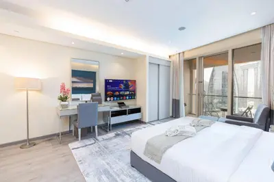 a bedroom with a bed and a desk with a computer at PVH - Emaar Residences - Burj Khalifa View Studio in Dubai