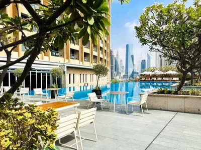 a hotel patio with tables and chairs and a pool at PVH - Emaar Residences - Burj Khalifa View Studio in Dubai