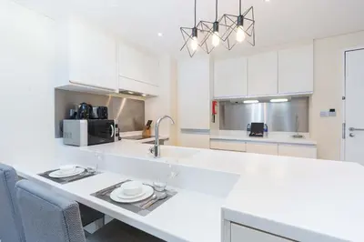 a kitchen with white cabinets and a white counter top at PVH - Emaar Residences - Burj Khalifa View Studio in Dubai