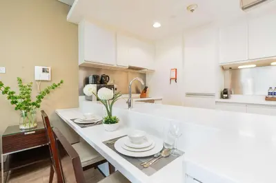 a kitchen with white cabinets and a white counter top at PVH - Dubai Mall Access 1BR - Emaar Fashion Avenue in Dubai