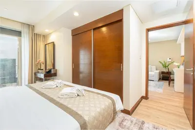 a bedroom with a bed and a wooden wall at PVH - Dubai Mall Access 1BR - Emaar Fashion Avenue in Dubai